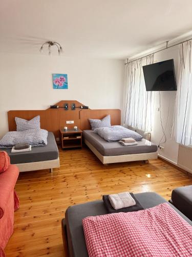 a living room with two beds and a flat screen tv at Pension Scheffler in Potsdam