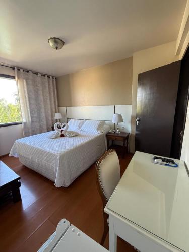 a hotel room with a bed and a desk with a desk at Hotel São Luiz in São Gabriel