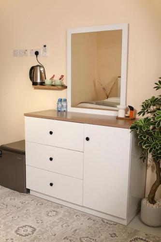 a white dresser with a mirror on top of it at رخاء للغرف الفندقية in Firq