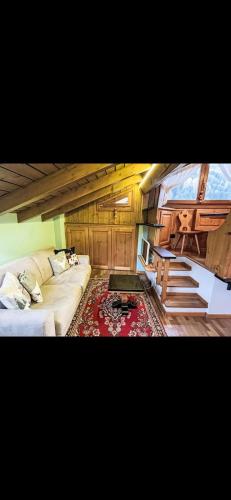 a living room with a couch and stairs in a room at Bilocale con vista sui monti in Pinzolo