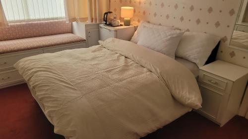 ein Bett mit weißen Laken und Kissen in einem Schlafzimmer in der Unterkunft Ansty view in Coventry
