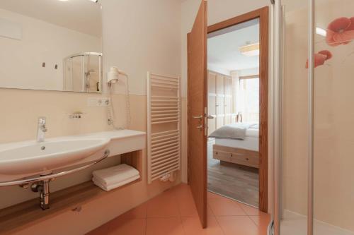 a bathroom with a sink and a mirror at Niedermair Nature Retreat in Parcines