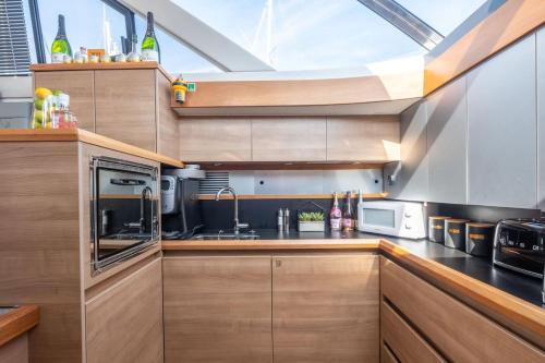 a kitchen with wooden cabinets and a skylight at 2BR Heated Yacht, Lymington Centre, Beautiful View in Lymington