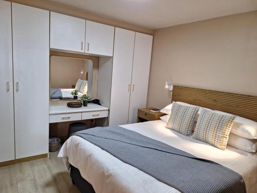 a bedroom with a bed with a desk and a mirror at Lovista in Tygerberg Hills