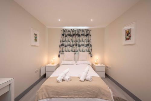a bedroom with a large bed with two pillows at The Burleigh palace in Cambridge