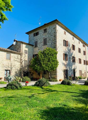 a large stone building with a grass yard at Agriturismo Del Casato in Sansepolcro