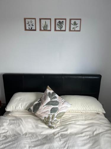 a bed with a black headboard and four pictures on the wall at The C & A Studio in Killala