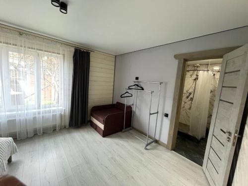 a living room with a chair and a window at Тростян та річка in Slavske