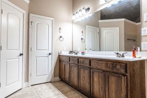 a bathroom with a sink and a large mirror at Osile Villa in DeSoto