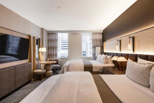 a hotel room with two beds and a flat screen tv at The Westin Minneapolis in Minneapolis