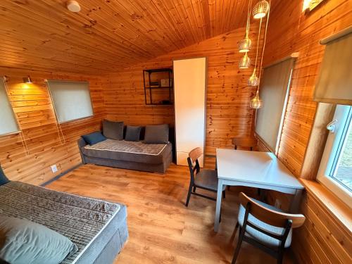 a room with a bed and a couch and a table at Katase Tiny House, Secluded Beachfront Cabin on Lake Peipus in Katase