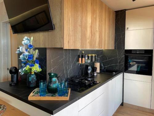 a kitchen with a counter with vases and flowers on it at Sunset Coast - Paradise Cottage in Drage