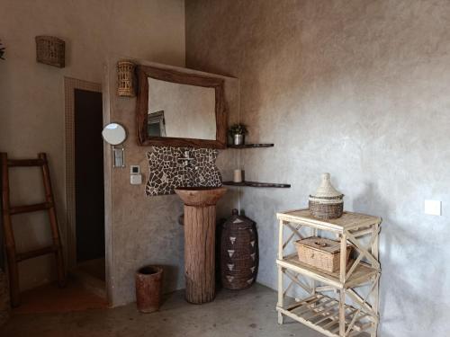 a corner of a room with a mirror and a table at Maison Talouma in Saly Portudal