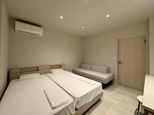 a small bedroom with two beds and a couch at Hope Private Villa tateyama in Tateyama