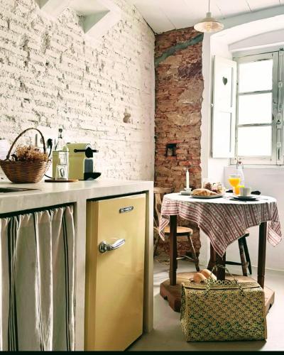 a kitchen with a yellow refrigerator next to a table at Casas Velhinhas - Apartº Aconchego e Apartº Calmaria in Estremoz