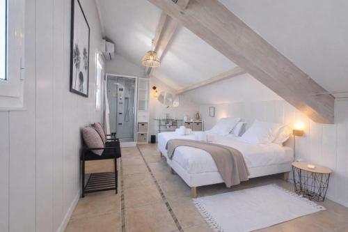 a bedroom with a large white bed in a attic at Suite Notre Dame - Appartements in Cannes
