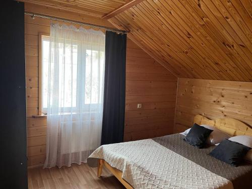 a bedroom with a bed in a wooden cabin at Тростян та річка in Slavske