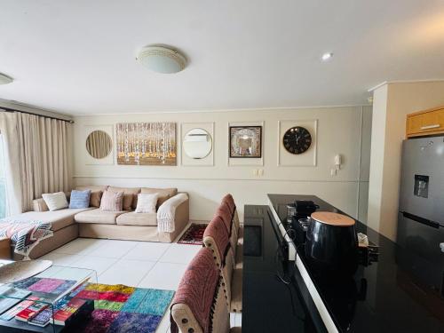 a living room with a couch and a table at Manhattan Escape Suite By Ezey Tours in Cape Town