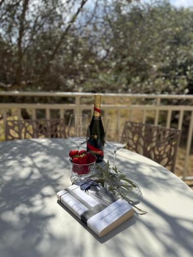 a bottle of wine and a basket of berries on a table at Villa Annunziata Suite in Aragona