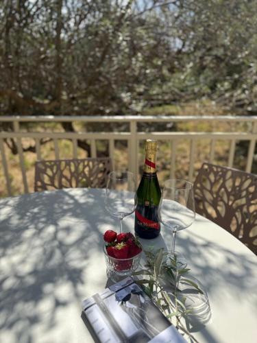 a bottle of wine and two glasses on a table at Villa Annunziata Suite in Aragona
