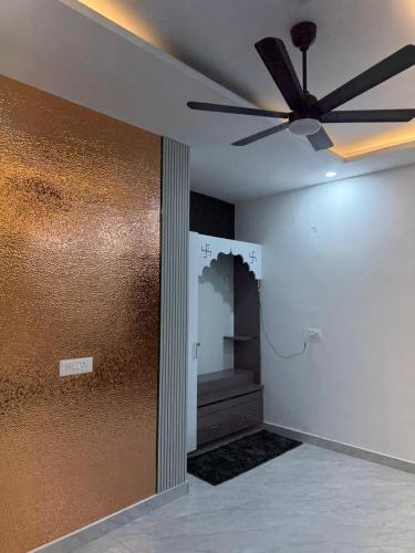 a living room with a ceiling fan and a wall at Aanya Bnb in Zirakpur