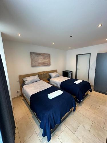 a bedroom with two beds with blue and white sheets at Studio 21 in Hasselroth