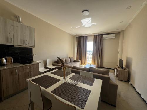 una cucina e un soggiorno con un tavolo e un divano di Light Apartment a Sarandë
