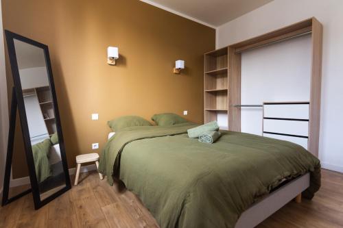 a bedroom with a large bed and a mirror at Maison avec parking la Flocellière in La Flocellière