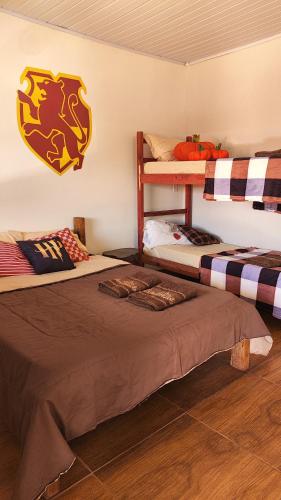 two bunk beds in a room with a football sign on the wall at Pousada e Camping Caldeirão Furado in São Thomé das Letras