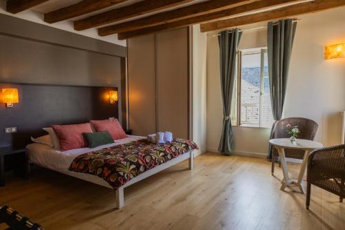 a bedroom with a bed and a table and a window at Le clos aux roses in Chédigny