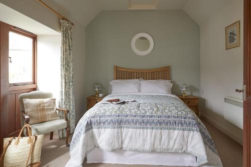 a bedroom with a large bed and a chair at Willows in Calbourne
