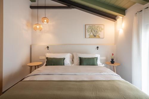 a bedroom with a large bed with green pillows at Vigne del Malina - Agriturismo & Winery in Orzano