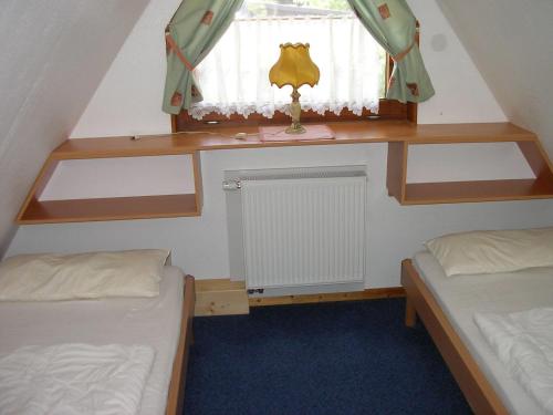 a small room with two beds and a window at PRHS08001-FeHaus-Diekkroon in Presen
