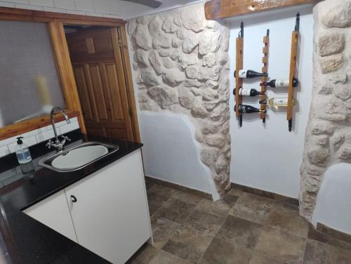 a bathroom with a sink and a stone wall at The Retreat in Las Encebras