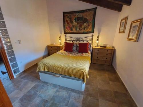 a bedroom with a bed with red pillows on it at The Retreat in Las Encebras