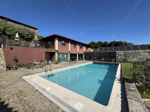 a swimming pool in a yard next to a building at Hotel Rural Alves - BRAGA - Casa Alves de Torneiros in Braga