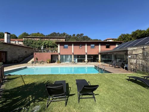 a yard with chairs and a swimming pool at Hotel Rural Alves - BRAGA - Casa Alves de Torneiros in Braga