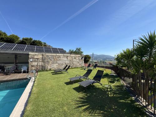 a yard with lounge chairs and a swimming pool at Hotel Rural Alves - BRAGA - Casa Alves de Torneiros in Braga