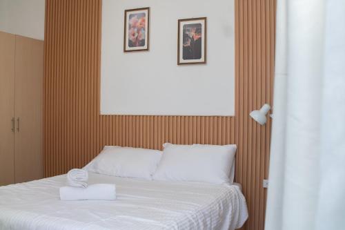 a bedroom with a white bed with three pictures on the wall at 206 Executive Granvia Suites in Cagayan de Oro