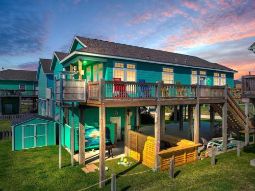 a house with a wrap around deck with a balcony at It's a Shellabration home in Crystal Beach