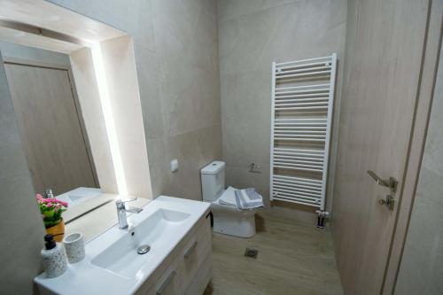 a bathroom with a sink and a toilet and a mirror at Agnanti in Agia Fotini