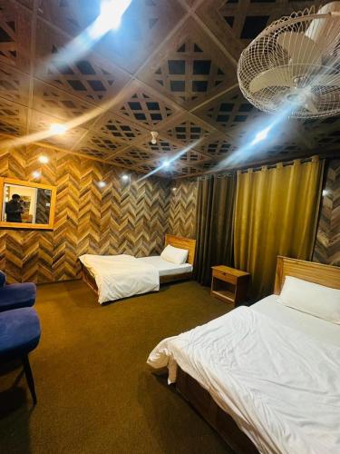 a room with two beds and a blue chair at North Paradise Guest House in Skardu