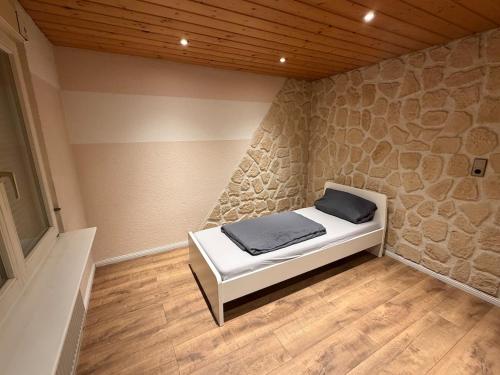 a bed in a room with a stone wall at Monteure Maisonette in Eggingen