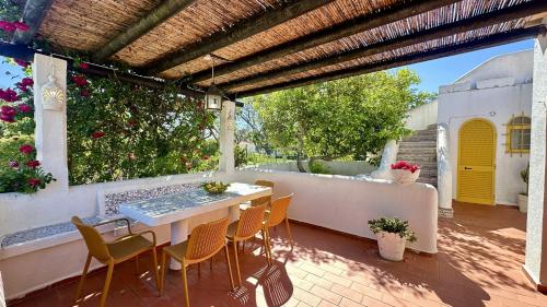 a patio with a table and chairs under a pergola at Golfe - Shared Pool - 7 Pax - Vilamoura in Vilamoura