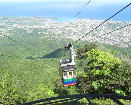 a cable car flying over a lush green mountain at Bahia Residence Cabarete in Cabarete