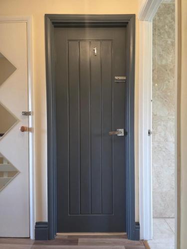 a grey door in a hallway with a stairwell at Reading West Homestay in Reading