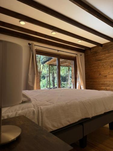 a large bed in a room with a window at Casa Mayay in Ranco