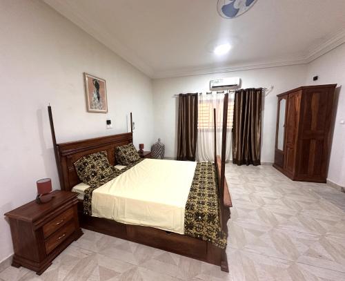 a bedroom with a bed and a dresser in it at Résidence du Golf in Bamako