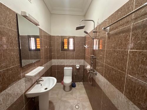a bathroom with a sink and a toilet and a mirror at Résidence du Golf in Bamako