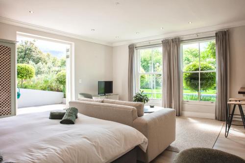 ein Schlafzimmer mit einem Bett, einer Couch und einem Fenster in der Unterkunft Francolin Studio in Kapstadt